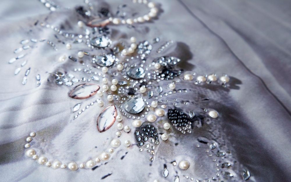 Decorazione di pietre, borchie e strass su tessuto